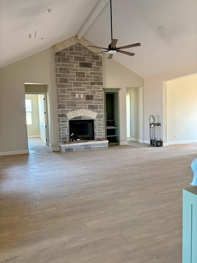 5605 E County Rd 94, Midland, TX 79706 - unfurnished living room with a fireplace, a ceiling fan, baseboards, beam ceiling, and light wood-style flooring