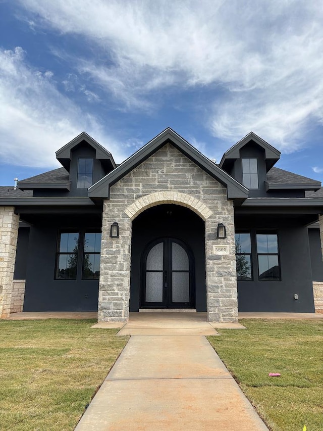 5605 E County Rd 94, Midland, TX 79706 - view of front facade featuring a front lawn, french doors, stone siding, and stucco siding