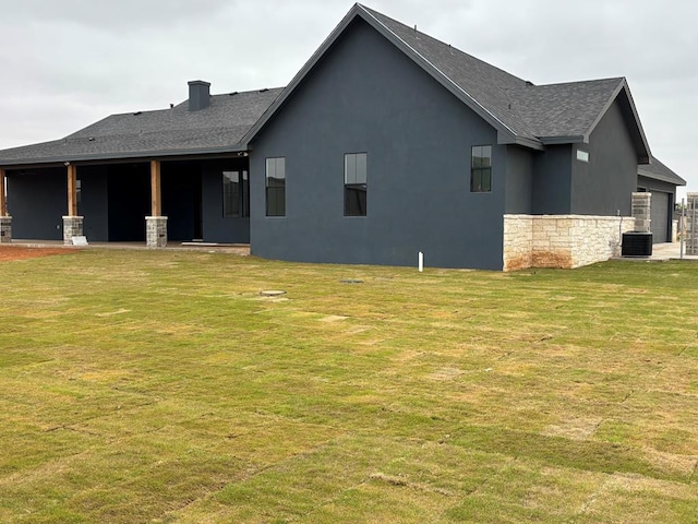 5605 E County Rd 94, Midland, TX 79706 - rear view of property featuring roof with shingles, central AC, stone siding, and a yard