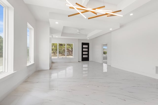 2607 Hoya Dr, Midland, TX 79707 - spare room featuring a tray ceiling, recessed lighting, light marble finish floors, a chandelier, and a ceiling fan