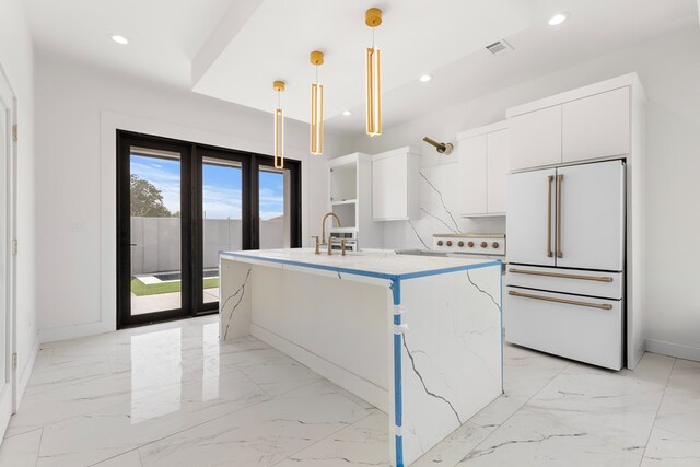 2607 Hoya Dr, Midland, TX 79707 - kitchen featuring high end white fridge, white cabinets, a center island with sink, decorative light fixtures, and light marble finish flooring