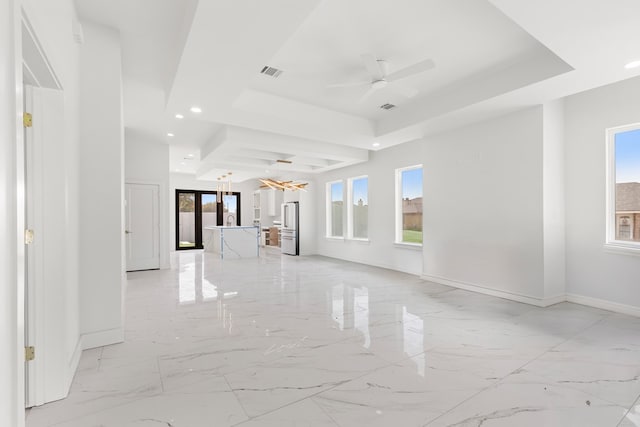 2607 Hoya Dr, Midland, TX 79707 - unfurnished living room featuring a raised ceiling, light marble finish flooring, ceiling fan, recessed lighting, and a chandelier