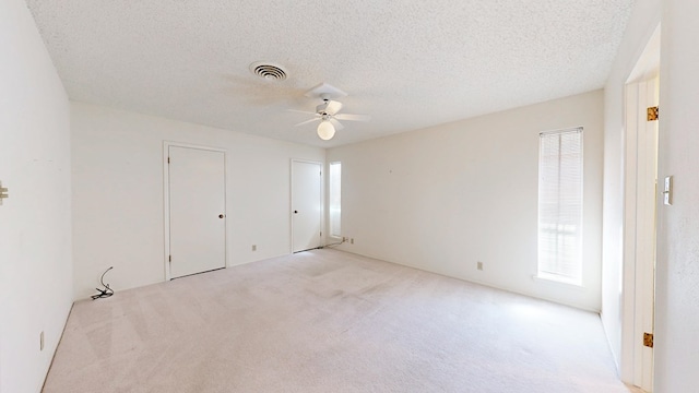 1007 Shirley Ln, Midland, TX 79705 - unfurnished bedroom featuring carpet floors, ceiling fan, a textured ceiling, and multiple closets