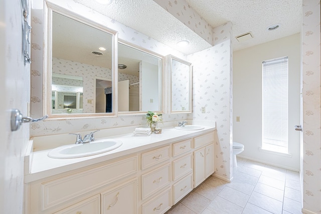 1007 Shirley Ln, Midland, TX 79705 - full bath featuring wallpapered walls, double vanity, a textured ceiling, and tile patterned flooring