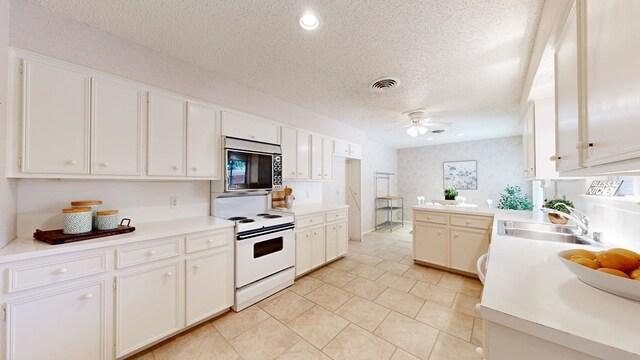 1007 Shirley Ln, Midland, TX 79705 - kitchen featuring stainless steel microwave, white electric range, a textured ceiling, ceiling fan, and light countertops