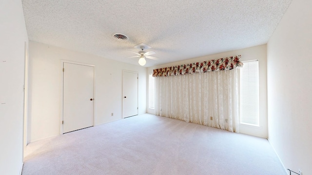 1007 Shirley Ln, Midland, TX 79705 - unfurnished bedroom featuring carpet, multiple windows, a ceiling fan, and a textured ceiling