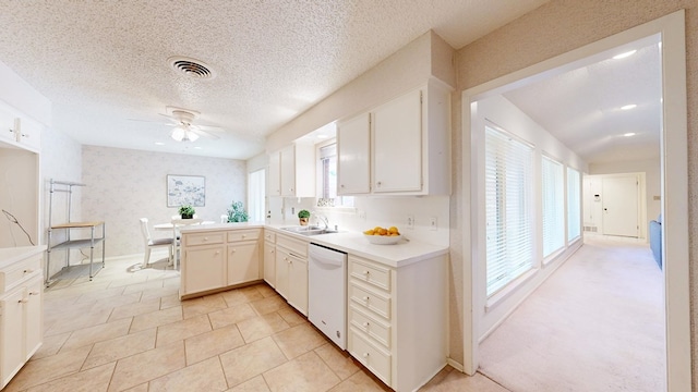 1007 Shirley Ln, Midland, TX 79705 - kitchen with dishwasher, a ceiling fan, healthy amount of natural light, a peninsula, and a textured ceiling