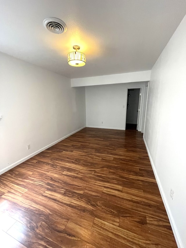 spare room featuring dark wood-style floors, baseboards, and visible vents