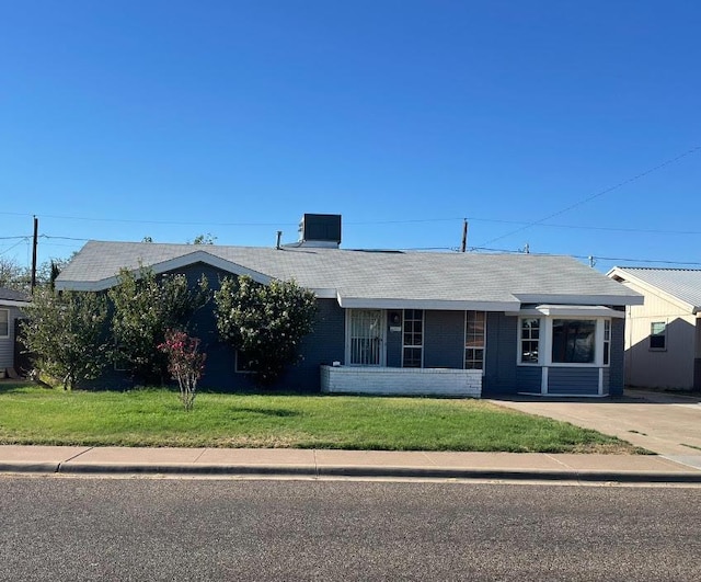 ranch-style house featuring central AC and a front yard