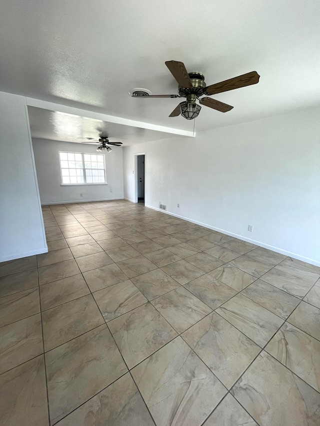 unfurnished room with a ceiling fan, visible vents, and baseboards