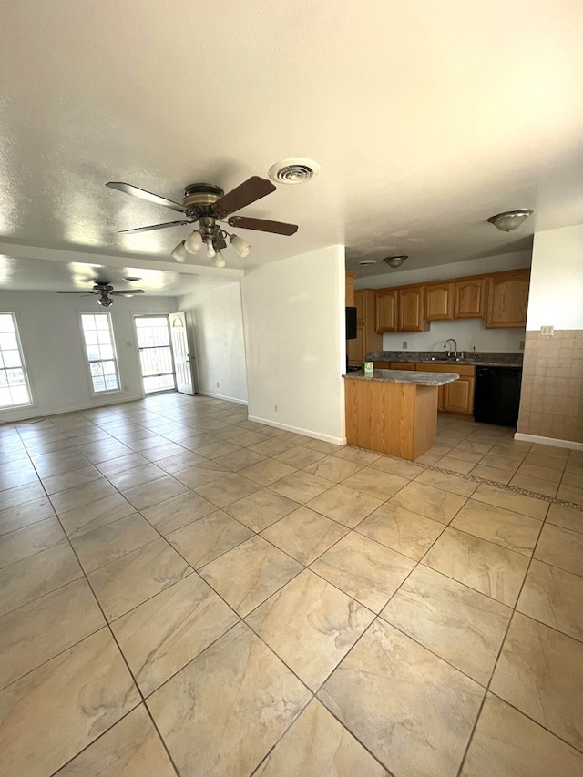 unfurnished living room featuring light tile patterned flooring, ceiling fan, sink, and a textured ceiling