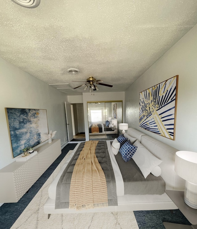 carpeted bedroom featuring a textured ceiling, a closet, visible vents, and a ceiling fan