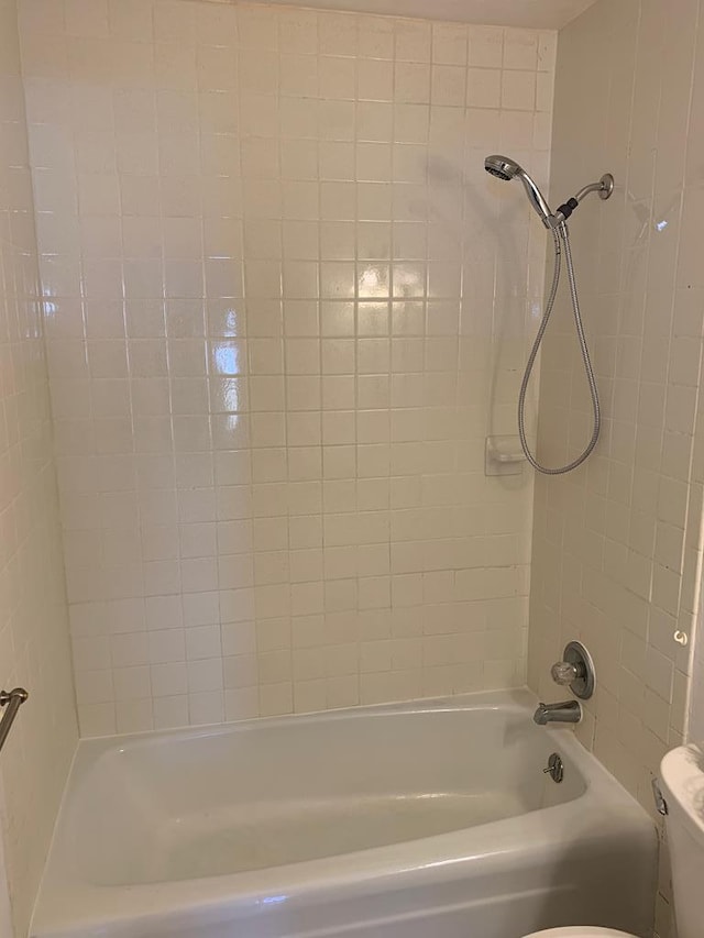 bathroom with bathtub / shower combination and toilet