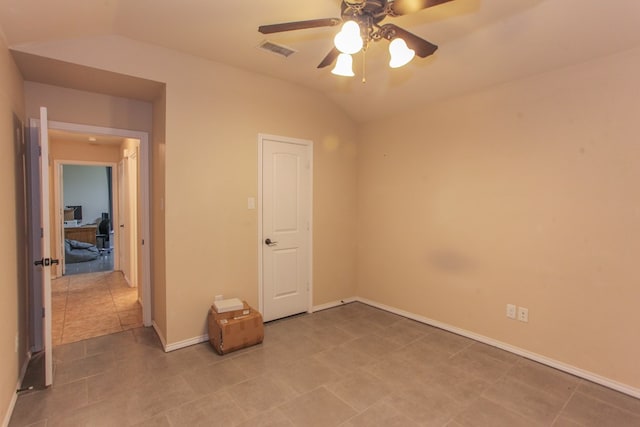 empty room with tile patterned flooring, ceiling fan, and lofted ceiling