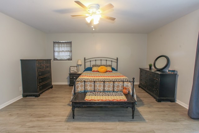 bedroom featuring a ceiling fan, baseboards, and light wood-style flooring