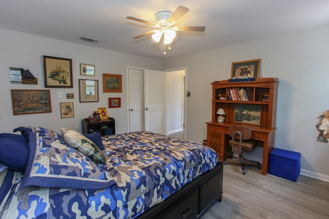 bedroom featuring ceiling fan, baseboards, visible vents, and wood finished floors