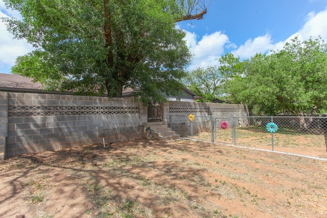 view of yard with a fenced backyard and a gate