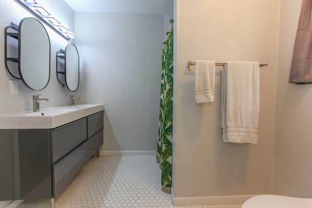 full bathroom featuring baseboards, a sink, double vanity, and a shower with curtain