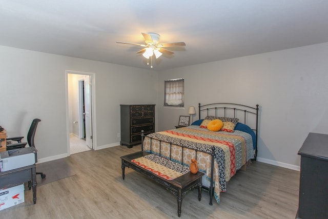 bedroom with a ceiling fan, baseboards, and wood finished floors