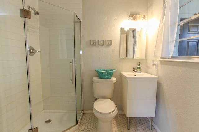 bathroom featuring a shower stall, vanity, tile patterned floors, toilet, and a textured wall