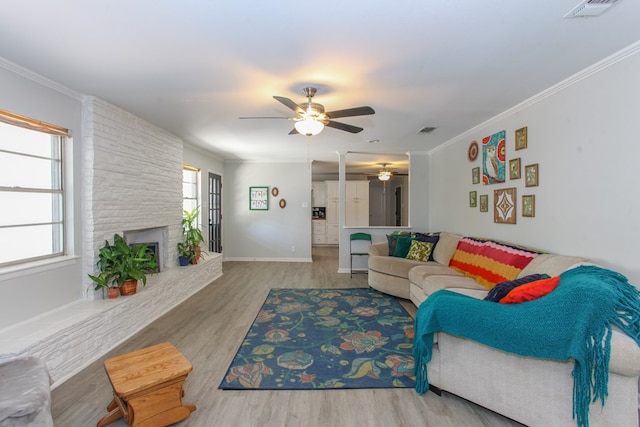 living room with visible vents, plenty of natural light, ceiling fan, and wood finished floors