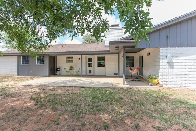 rear view of property with a patio and brick siding