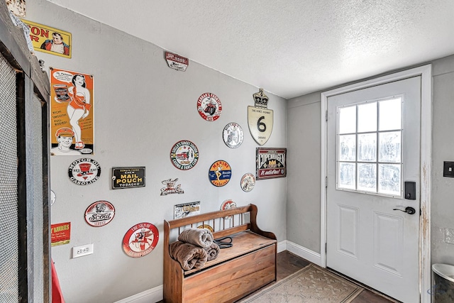 doorway to outside featuring a textured ceiling