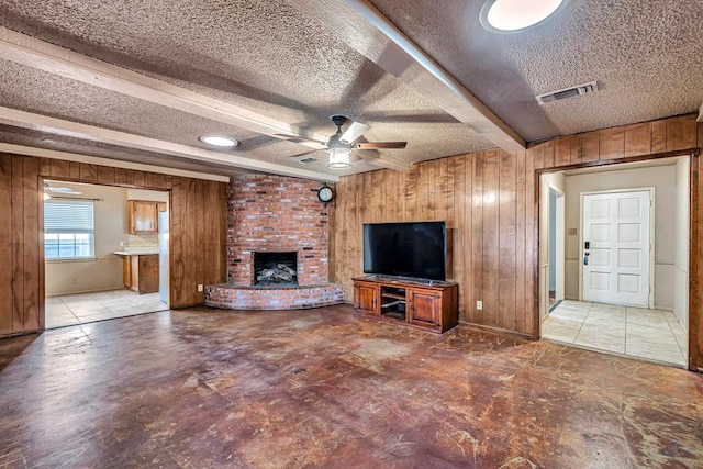 2821 Metz Dr, Midland, TX 79705 - unfurnished living room featuring wooden walls, a textured ceiling, a ceiling fan, and a fireplace