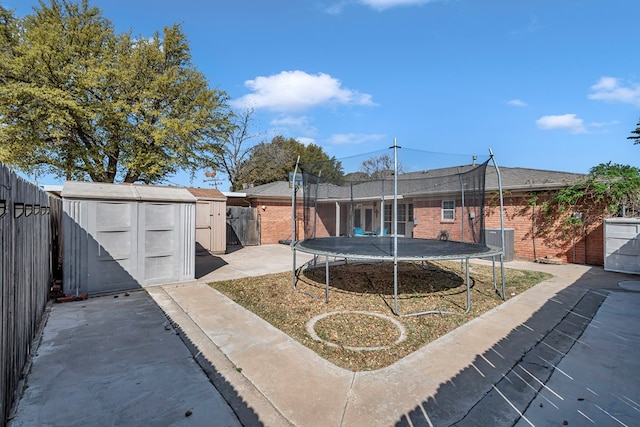 2821 Metz Dr, Midland, TX 79705 - rear view of property with a trampoline, brick siding, and a fenced backyard