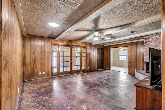 2821 Metz Dr, Midland, TX 79705 - unfurnished living room with a textured ceiling, wooden walls, french doors, a ceiling fan, and a brick fireplace