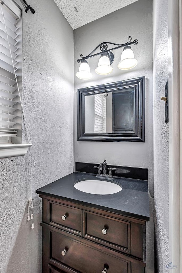 2821 Metz Dr, Midland, TX 79705 - bathroom with a textured wall, vanity, and a textured ceiling
