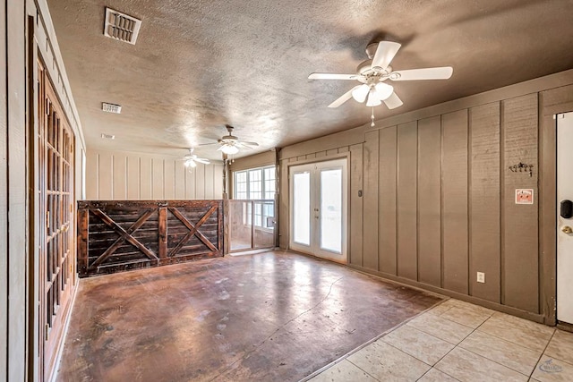 2821 Metz Dr, Midland, TX 79705 - spare room with ceiling fan, wooden walls, and a textured ceiling