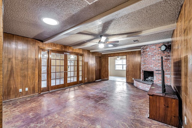 2821 Metz Dr, Midland, TX 79705 - unfurnished living room featuring french doors, wooden walls, a textured ceiling, a brick fireplace, and ceiling fan