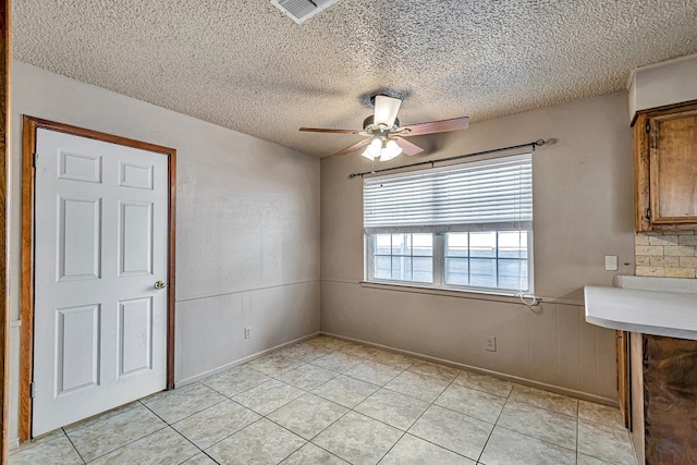 2821 Metz Dr, Midland, TX 79705 - unfurnished dining area with a textured ceiling, ceiling fan, and light tile patterned floors