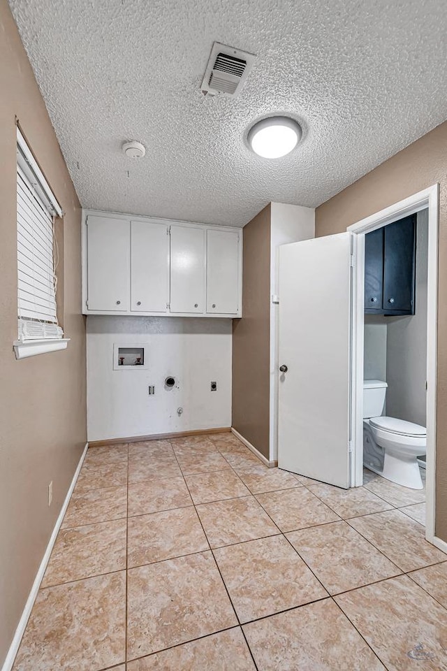 2821 Metz Dr, Midland, TX 79705 - laundry room featuring cabinet space, gas dryer hookup, hookup for an electric dryer, a textured ceiling, and washer hookup