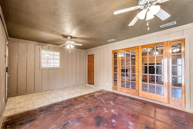 2821 Metz Dr, Midland, TX 79705 - empty room with ceiling fan, french doors, a textured ceiling, and wooden walls