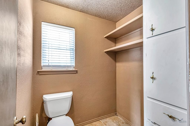 2821 Metz Dr, Midland, TX 79705 - bathroom featuring a textured ceiling, toilet, and tile patterned floors