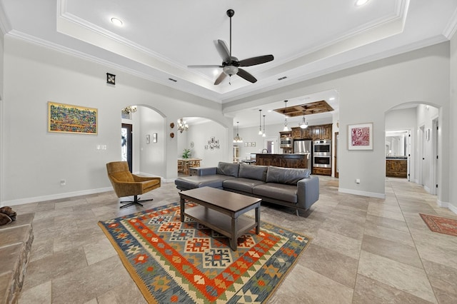 5514 Casa Grande Trl, Midland, TX 79707 - living area with arched walkways, a raised ceiling, ceiling fan, ornamental molding, and baseboards
