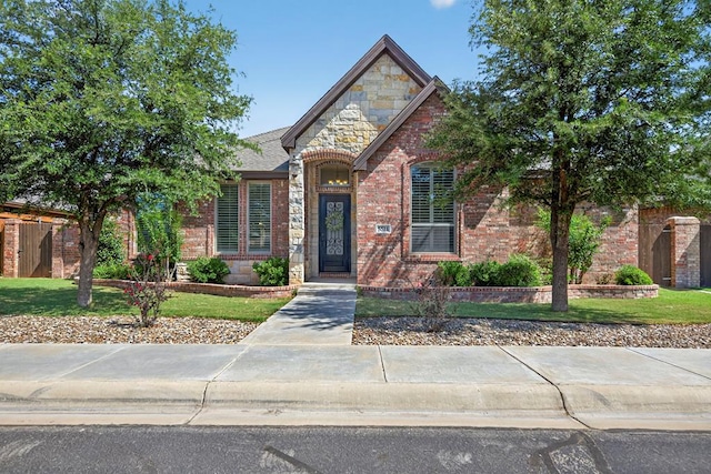 5514 Casa Grande Trl, Midland, TX 79707 - view of front of property featuring a front lawn, stone siding, and brick siding