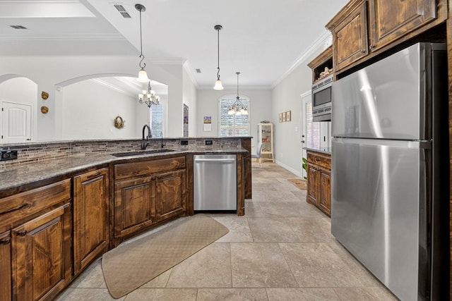 5514 Casa Grande Trl, Midland, TX 79707 - kitchen featuring stainless steel appliances, a chandelier, a sink, ornamental molding, and arched walkways