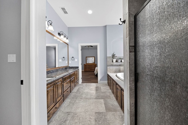 5514 Casa Grande Trl, Midland, TX 79707 - full bathroom with double vanity, a garden tub, stone finish flooring, and ensuite bath