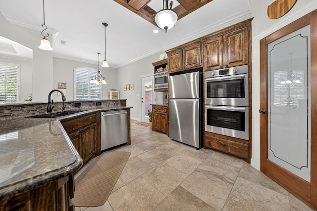 5514 Casa Grande Trl, Midland, TX 79707 - kitchen with stainless steel appliances, a sink, crown molding, dark stone counters, and a chandelier