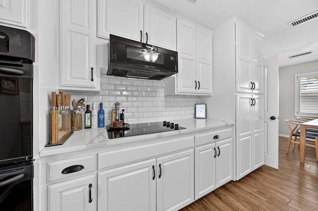 2802 Cimmaron Ave, Midland, TX 79705 - kitchen with black appliances, backsplash, and white cabinetry