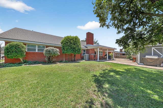2802 Cimmaron Ave, Midland, TX 79705 - back of property featuring a patio area, a chimney, brick siding, and a lawn