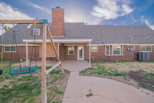 back of house with central AC, a patio, a chimney, and brick siding