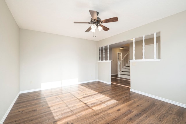 unfurnished room featuring ceiling fan, stairs, baseboards, and wood finished floors