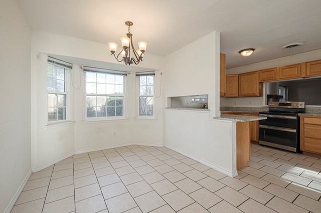 kitchen with a healthy amount of sunlight, a peninsula, visible vents, and range with two ovens