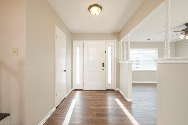 entryway with ornate columns, ceiling fan, baseboards, and wood finished floors