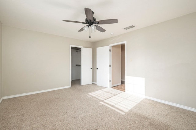 unfurnished bedroom with light carpet, ceiling fan, visible vents, and baseboards