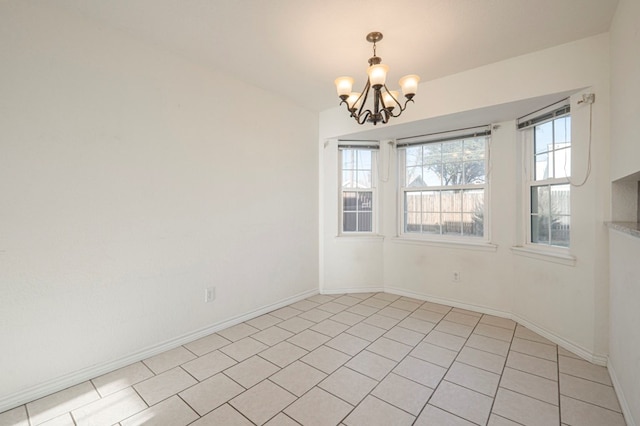 empty room featuring light tile patterned flooring, baseboards, and an inviting chandelier